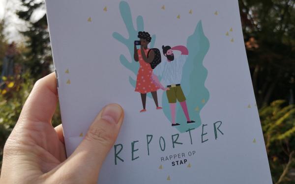 hand houdt reporterboekje Rapper op Stap vast